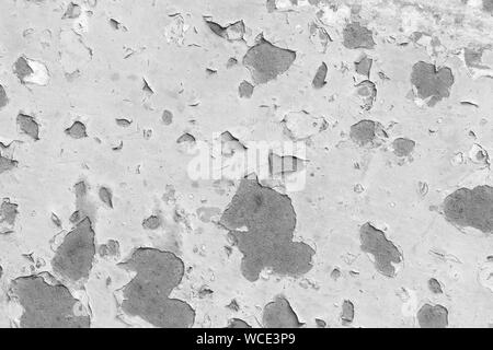 Close-up of a painted, weathered and worn sheet metal plate in black and white. Paint is partly peeled off revealing rusty metal. Abstract background. Stock Photo