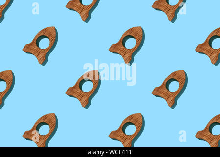 Wooden toy rocket creative pattern on blue background. Space concept. Stock Photo
