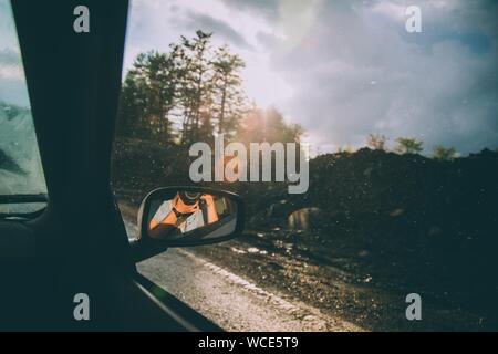 Beautiful shot of a photographer reflected in the car's side mirror with a blurred background Stock Photo