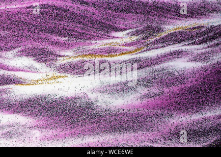 Colored quartz sand texture abstract background, black, white, gold and purple. Stock Photo