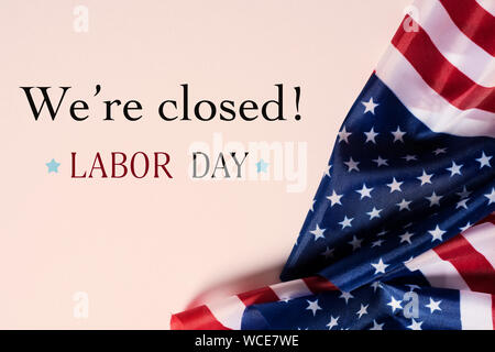 some flags of the United States and the text we are closed, labor day, on a beige background Stock Photo