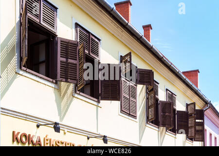 Old house front with window shutters open and closed Stock Photo