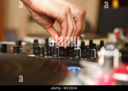 Professional hip hop dj mixes tracks on sound mixer controller in night club.Female disc jockey playing tracks on party.Audio equipment for playing mu Stock Photo