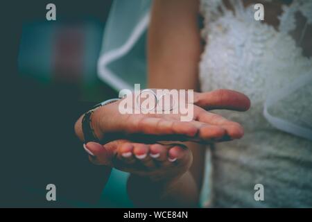 Closeup of a bride and a groom holding there weeding rings with a blurred background Stock Photo