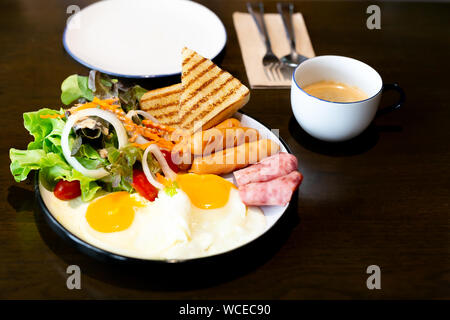 Breakfast set, with vegetable, ham, bacon, fried egg, sausage and cup of coffee. Stock Photo