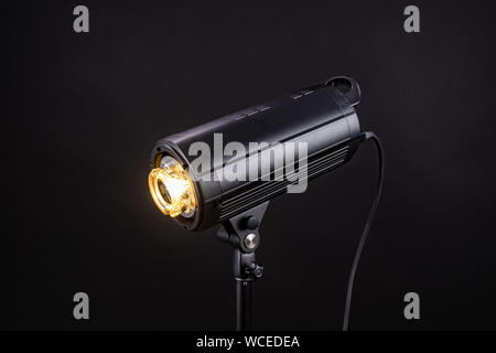 Head of studio flash strobe lamp light. Side view professional studio photography lighting close up on black background. ring lamp Stock Photo