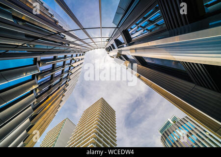 Modern skyscrapers in metropolis center. High-rise buildings on blue sky background. White clouds and sunlight. Prague city, capital of Czech Republic. Stock Photo