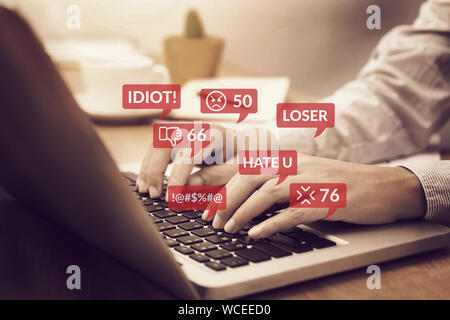 cyber bullying concept. people using notebook computer laptop for social media interactions with notification icons of hate speech and mean comment in Stock Photo