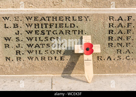 Second World War Memorial in Hexham, Northumberland, with a red poppy on a wooden cross remembering the loss of a local boy over the Indian Ocean. Stock Photo