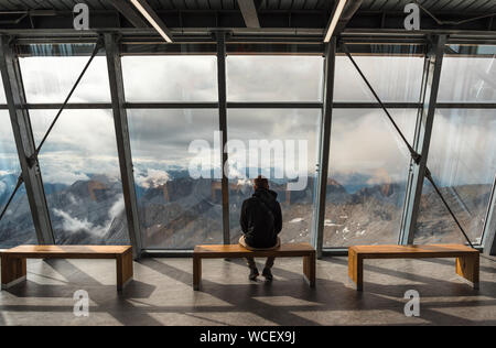 A man sitting on the observation deck on a Zugspitze mountain. Stock Photo