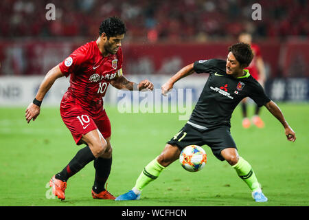 Brazilian football player Givanildo Vieira de Sousa, known as Hulk, of Shanghai SIPG F.C., left, tries to get the ball at the quarter final match against Urawa Red Diamonds during 2019 Asian Champions League in Shanghai, China, 27 August 2019. Stock Photo