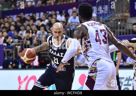 A basketball player of Greece, left, keeps the ball while defended by a member of Venezuela, right, during 2019 Suzhou International Basketball Challenge in Suzhou city, east China's Jiangsu province, 27 August 2019. Greece defeated Venezuela with 74-51 and wins the championship of 2019 Suzhou International Basketball Challenge in Suzhou city, east China's Jiangsu province, 27 August 2019. Stock Photo