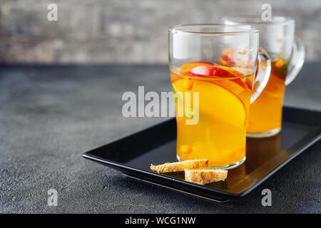 Two glass cups with apple tea on grey background Stock Photo