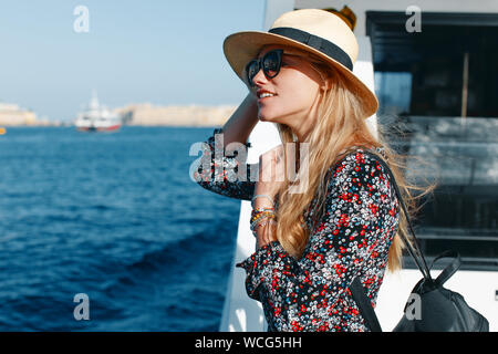 Happy blonde Mediterranean woman amazed by panorama on cruise ship Stock Photo