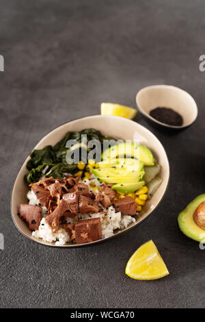 Vegan healthy bowl with rice, salad and jackfruit on dark backround Stock Photo