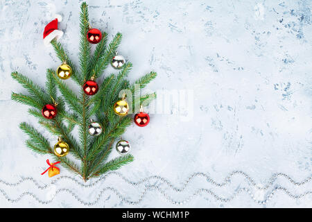 New Year and Christmas abstract snowy winter landscape, Santa Claus hat hanging on decorated Christmas tree and bag with gifts under it on snowdrifts Stock Photo