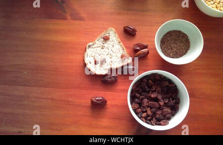 Bowl of raisins, flaxseeds, figs, and other dried fruits in white bowls Stock Photo