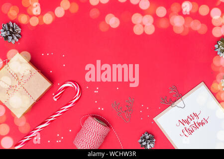 Christmas flat lay with gift box, candy cone and other small elements and place for text. Light effect. Stock Photo
