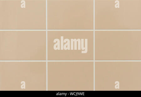 Beige ceramic tile on the wall in the bathroom. Background from beige tiles. Stock Photo