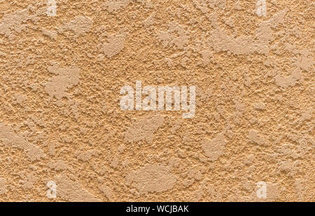 Texture of beige decorative plaster on the wall in the interior of the room. Stock Photo