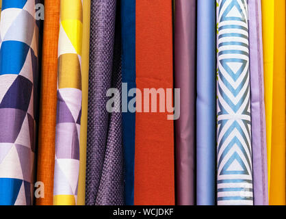 Multicolored curtain designs in a retail store window. Samples of the texture of multi-colored fabrics. Stock Photo