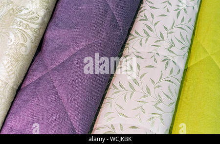 Bedspreads in different colors. Background from fabric of different colors. Stock Photo