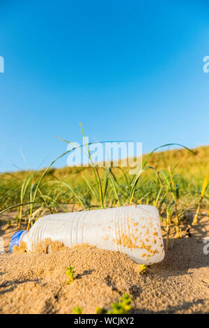 Plastic waste (plastic bottle) pollution on a beach in Wales UK