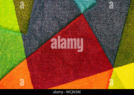 Texture of a multi-colored carpet. Background of the carpet with multi-colored inserts. Stock Photo