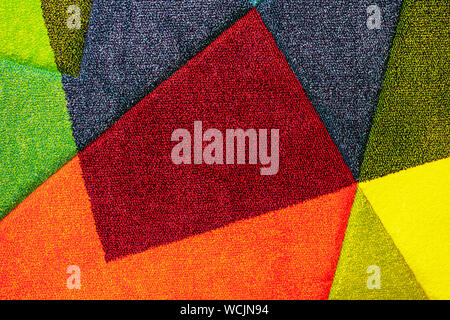 Texture of a multi-colored carpet. Background of the carpet with multi-colored inserts. Stock Photo