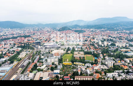 Aerial view of city Graz from helicopter drone with district Jakomini and the east railway station, event-center Messe on a cloudy summer day in Austr Stock Photo