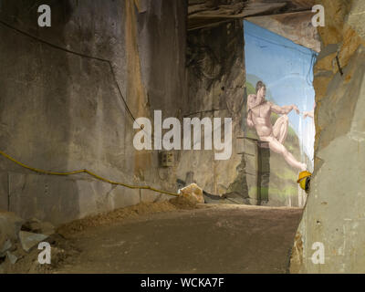 MASSA CARRARA, ITALY - AUGUST 23, 2019: Most marble quarries are open pit but some are underground.Here inside one with homage artwork to Michelangelo Stock Photo