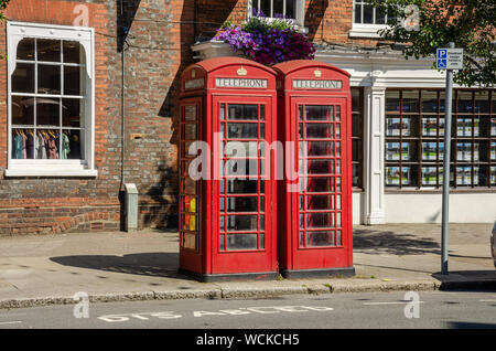 Traditional red British telephone boxes on the pavement alongside The High Street in Marlow, Buckinghamshire, UK Stock Photo