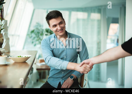 handshake beetweet two men after successful negotiations in the cafe . Stock Photo