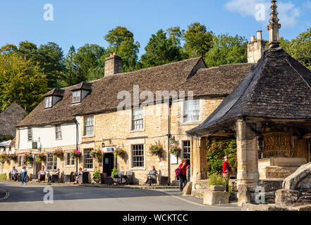 The castle Inn and hotel behind the covered Market cross in the market place Castle Combe village centre Wiltshire england uk gb Europe Stock Photo