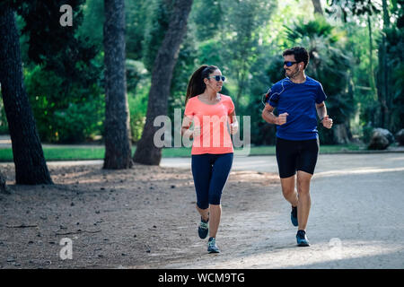 young couple running through the park and listening to music. healthy living concept. Stock Photo
