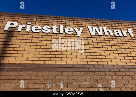Sign on a brick wall for Priestley Wharf, an office development on the Digbeth Branch Canal, Birmingham, UK