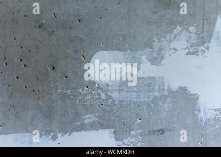 Puttying the wall with white putty, concrete wall with smeared irregularities, apartment repair Stock Photo