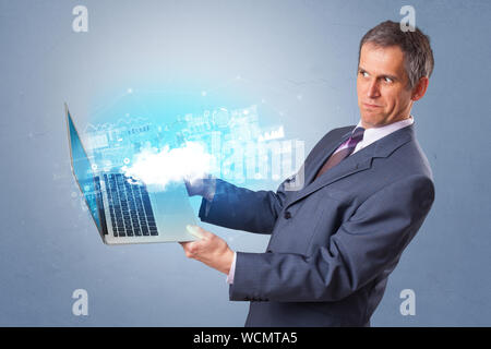 Man holding laptop projecting notifications, symbols and information based on cloud technology system Stock Photo