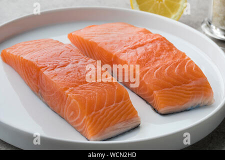 Fresh raw salmon steaks on a dish ready to cook Stock Photo