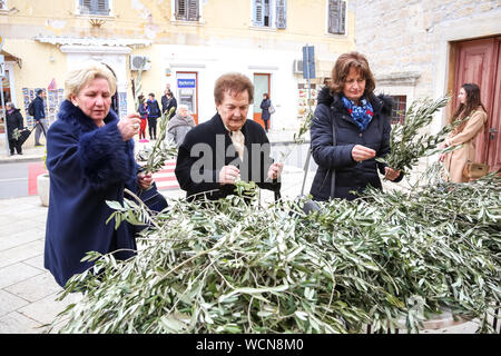 Umag, Croatia - 14, April 2019 : Catholics in front of Church of St. Roche taking olive branches, symbol of Easter celebration to sanctify them on the Stock Photo