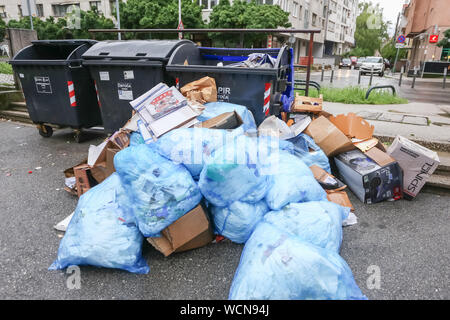 Zagreb, Croatia - May 29, 2019 : A pile of garbage bags next to a garbage containers in the street of Zagreb, Croatia Stock Photo