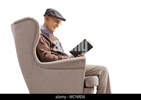 Senior gentleman in an armchair reading a book isolated on white background Stock Photo