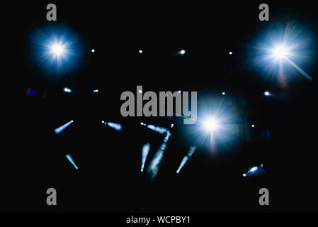 Black background with light bulbs illuminating the darkness with sparkles. Stock Photo