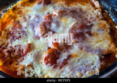 Baked vegetables with ham cheese in a fireproof pan Stock Photo