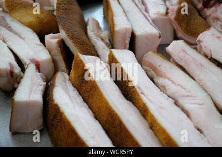 Showcase with variety of raw meats, bacon and lard on street market or farm market. Meat products of the store. Close-up. Stock Photo