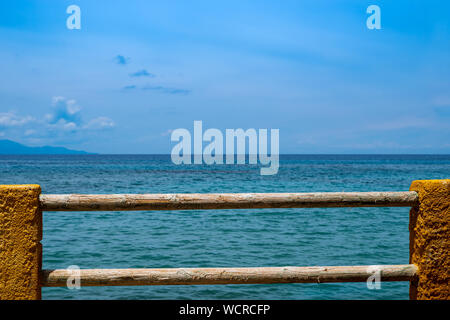 Wonderful view over the blue Mediterranean to the horizon, fence of wood and stone in the foreground Stock Photo