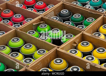 Selection of assorted colors graffiti spray paint cans in cardboard boxes at retail display of open market, high angle view Stock Photo