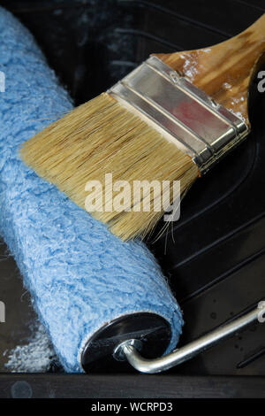 Paintbrush and roller paint on the tray close-up picture Stock Photo