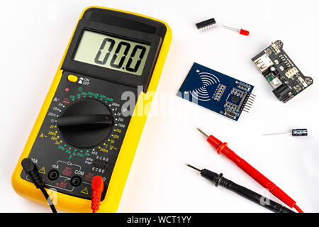 Yellow digital multimeter electronic measurement device tool with red and black cables microc chip circuit board led and micro controller isolated on Stock Photo