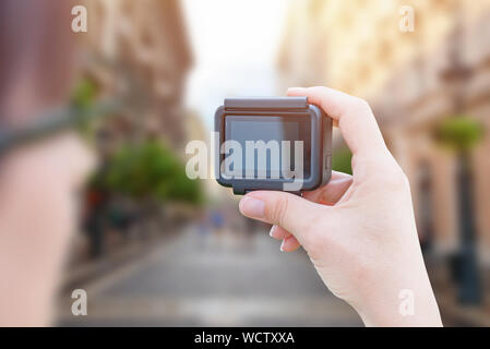 Influencer makes video with action camera in city street concept. Stock Photo